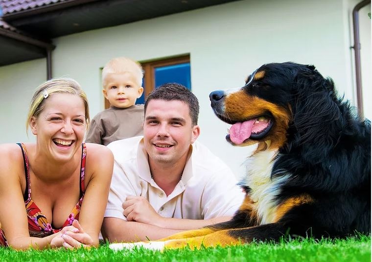 Smiling family relaxing outdoors with their dog